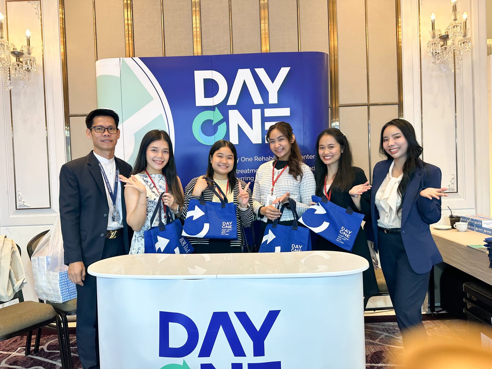 ทีมงาน Day One และผู้เข้าร่วมประชุมที่บูธ พร้อมของที่ระลึก