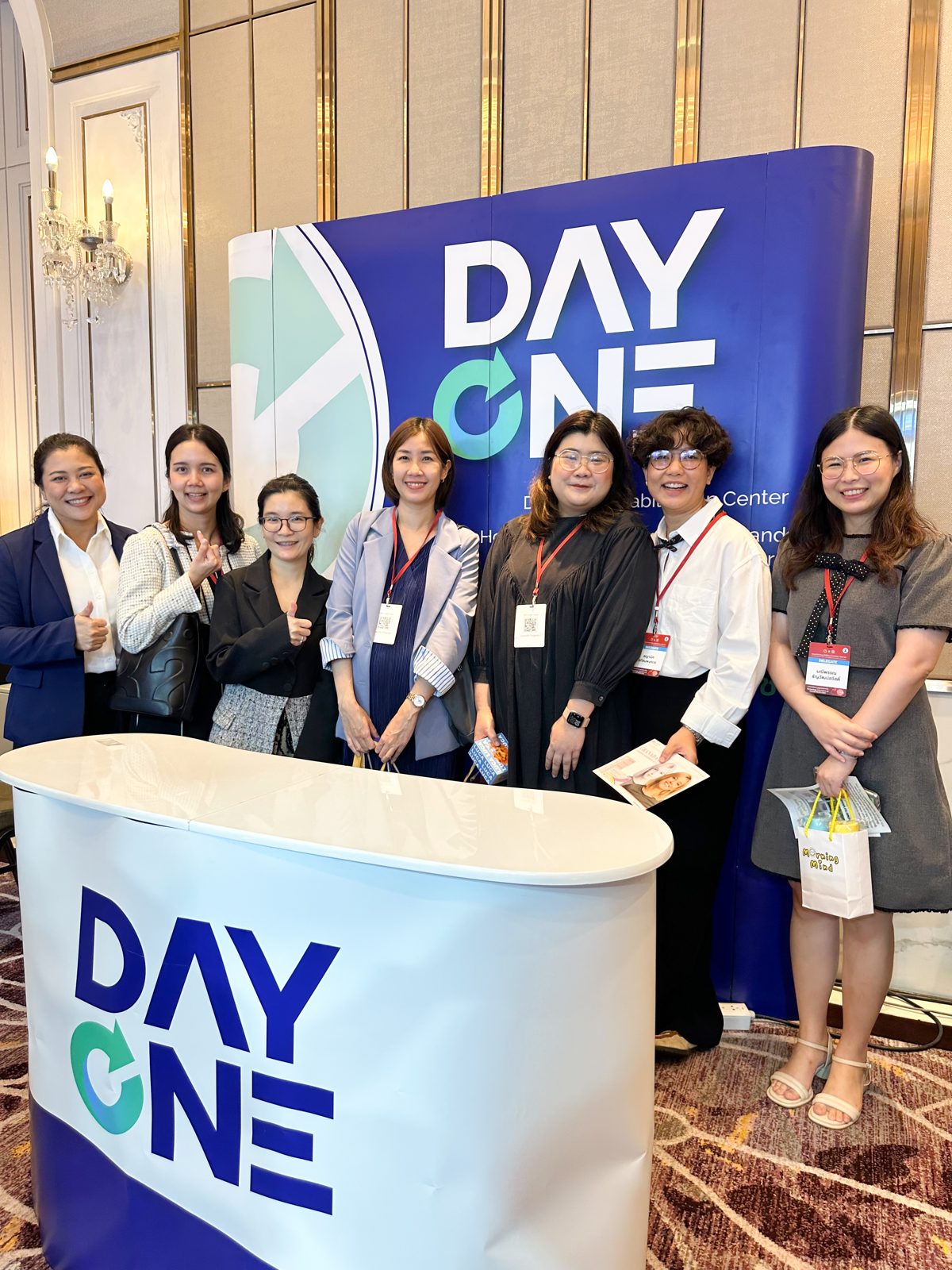 ทีมงาน Day One ต้อนรับผู้เข้าร่วมประชุมที่บูธ