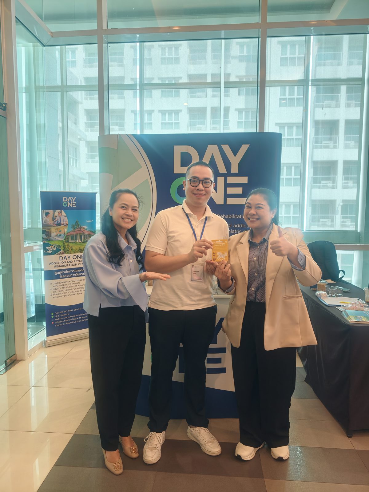 ผู้เข้าร่วมประชุมถ่ายภาพร่วมกับทีมงานที่บูธ Day One